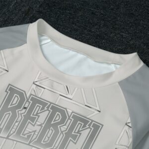 A lounge set featuring a long-sleeve top and matching joggers with a grey base, bold 'Rebel' typography, and white geometric accents. The set is made from soft, breathable fabric, perfect for lounging or casual wear.