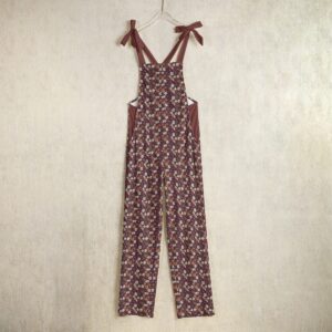 A chic pair of floral overalls from the Blooming Ember Collection, featuring earthy maroon and orange tones with adjustable tie straps for all-day comfort.