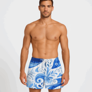 A pair of men's swim shorts with pockets, featuring an abstract blue and white floral and swirl design inspired by Mediterranean tile. Includes a white drawstring and relaxed fit above the knee.