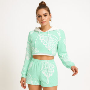 A mint green fleece hoodie and shorts set featuring a large white butterfly graphic. The hoodie is cropped with long sleeves and a drawstring hood, while the matching shorts have an elastic waistband and a relaxed fit. The model wears the set with confidence and a top knot hairstyle.